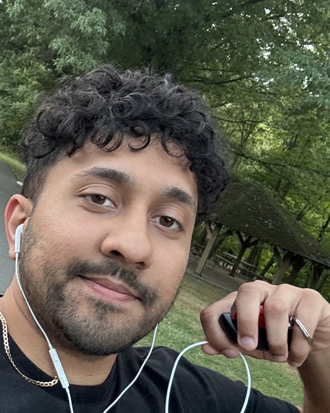 Ryan Raghubans on a wooded park trail, wearing earbuds.